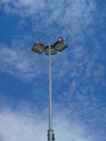 Street light pole against a sunny summer blue sky and scatter white clouds, Close up telephoto shot, no people. Royalty Free Stock Photo