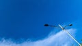 Street light under bright blue sky with white clouds Royalty Free Stock Photo