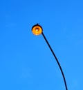 Street lighting lamp lit at dusk on a long pole Royalty Free Stock Photo