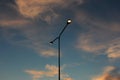 Street lighting a lamp post with two lights against a cloudy sky