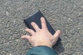 Street lighting. there is a wallet on the road on a sunny summer day. A human hand reaches out to him Royalty Free Stock Photo