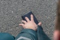 Street lighting. there is a wallet on the road on a sunny summer day. A human hand reaches out to him Royalty Free Stock Photo