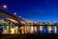 Street lights and car lights flow and reflect on the lake. Romantic night scene. Royalty Free Stock Photo