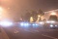 Street lights foggy misty night lamp cars road.