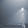 Street lights, foggy misty night, lamp post lanterns, deserted road in mist fog, wet asphalt tarmac, car headlights approaching Royalty Free Stock Photo