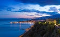 Street lights of Giardini Naxos near Taormina reflected in serene Ionian sea. Sunset view of coast of Sicily, Italy Royalty Free Stock Photo