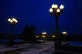 Street lights and road illuminated street lamps and snowing in winter at twilight. Royalty Free Stock Photo