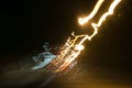 Street lights in speeding car in night time, light motion with slow speed shutter view from inside front of car.