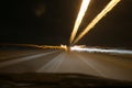 Street lights in speeding car in night time, light motion with slow speed shutter view from inside front of car. Royalty Free Stock Photo