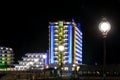 Street lights of yacht port and waterfront hotel building at night