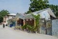 Street with local buildings, bikes and people during sunny day at the tropical island Maamigili Royalty Free Stock Photo