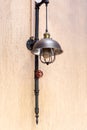 Street loft lamp of black pipe and red valve on the plaster wall.