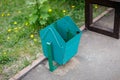 Street metallic empty trash bin near bench in the park Royalty Free Stock Photo