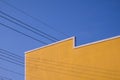 Street Minimal Architecture style of the old Vintage yellow Building Wall with electric cable lines against blue clear sky Royalty Free Stock Photo