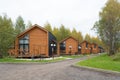 Street of modern small houses. Barnhouse style houses. The houses are surrounded by green trees. Nature