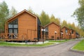 Street of modern small houses. Barnhouse style houses. The houses are surrounded by green trees. Nature