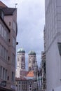 At the street in Munich. Between houses two towers of Frauenkirche