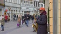 Street music instrumentalist black old man playing on saxophone for passersby people at city in unfocused in slow motion