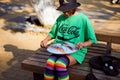 Street musician girl playing on steel tongue drum, cute girl playing tank drum on urban street