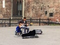 Street musician playing guitar at the entrance to the Castello Sforzesco