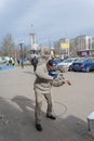 A street musician playing a musical instrument in front of a parking lot. A mature man with an electronic violin. Black baseball