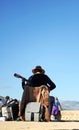 Street musician playing the spanish guitar with a blue sky background, Ronda, Spain