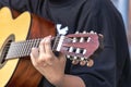 A street musician plays the guitar. Close-up of hands plucking chords. Guitar neck Royalty Free Stock Photo