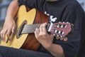 A street musician plays the guitar. Close-up of hands plucking chords. Guitar neck Royalty Free Stock Photo