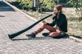 A street musician plays the trumpet in a city park.