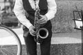 Street musician`s hands playing saxophone in an urban environment. Black and white picture