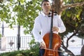 Street musician, young man playing cello in the street of big city, close up Royalty Free Stock Photo