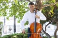 Street musician, young man playing cello in the street of big city, close up Royalty Free Stock Photo