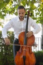 Street musician, young man playing cello in the street of big city, close up Royalty Free Stock Photo