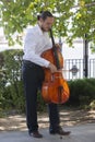 Street musician, young man playing cello in the street of big city, close up Royalty Free Stock Photo