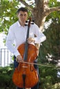 Street musician, young man playing cello in the street of big city, close up Royalty Free Stock Photo