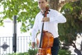 Street musician, young man playing cello in the street of big city, close up Royalty Free Stock Photo