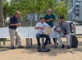 Street musicians on the bench. Bayanist at play. Men on vacation. Making money with music and singing Royalty Free Stock Photo