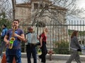 Street musicians play music at Adrianou Steet in Monastiraki as tourists pass by with Stoa of Attalos monument in the backgorund