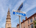 Street name signs against bright blue sky, and St Philip church on the background Royalty Free Stock Photo