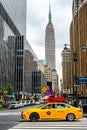 The street near Empire state tower with yellow taxi as foreground in Manhattan , New York city , USA