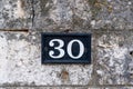 Street number 30. House address metal sign on stone wall Royalty Free Stock Photo