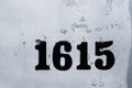 Street numbers 1615 on white chipped faded worn paint