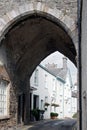 Street of old picturesque houses through the arch of the medieval gatehouse in the village of cartmel in cumbria Royalty Free Stock Photo