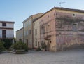 Street in old town of Tortoli with yellow pink houses and green plants. Sardinia, Italy, summer afternoon