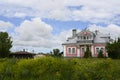 A street with one-story wooden houses and flowering shrubs in Suzdal, Russia