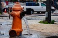 Street orange hydrant spreading water on the street