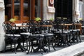 Street outdoor view of old fashion cozy cafe terrace with empty black wrought iron chairs and tables Royalty Free Stock Photo