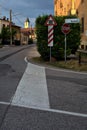 Street in the outskirt of an italian town with a sign and a railroad crossing in the background at sunset Royalty Free Stock Photo