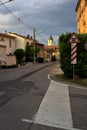 Street in the outskirt of an italian town with a sign and a railroad crossing in the background at sunset Royalty Free Stock Photo