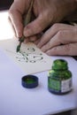 Street painter writing a celtic name with green pen